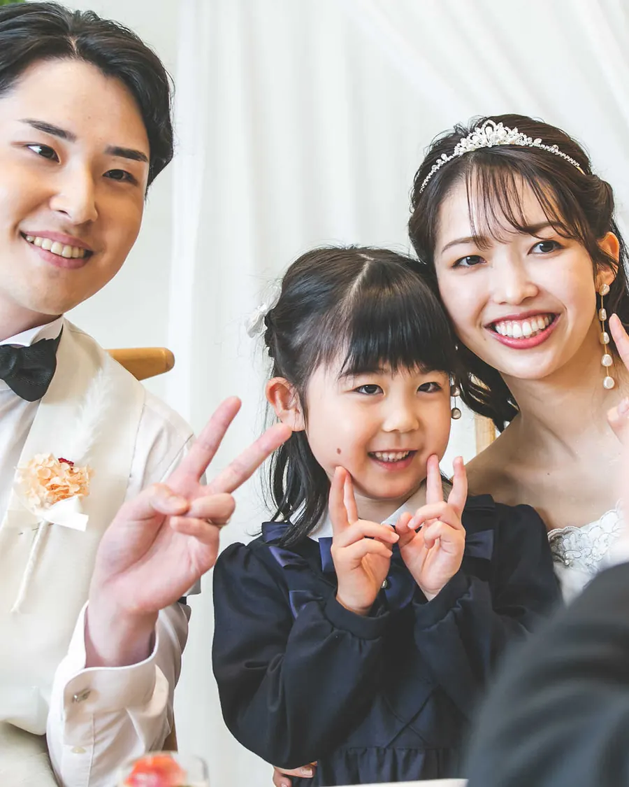 女の子と一緒に笑う新郎新婦