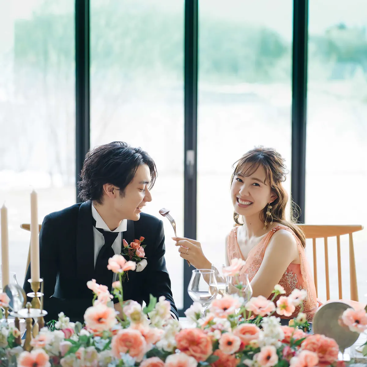 花に囲まれた席で話す新郎新婦