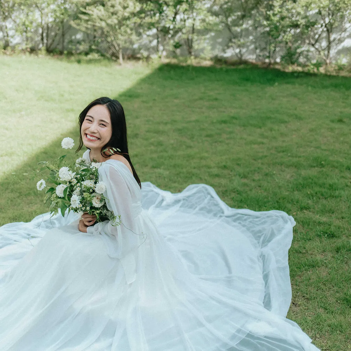 芝生に座るドレス姿の新婦